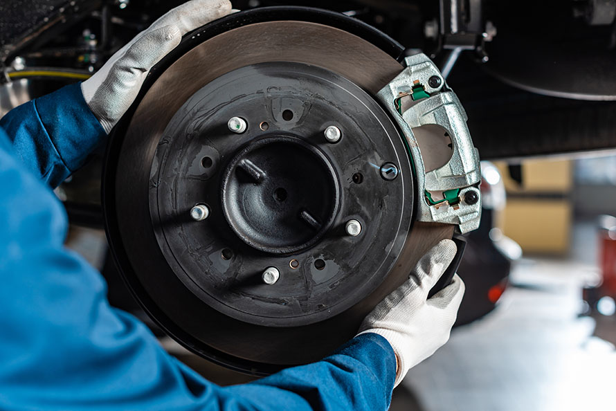 Auto repair technician performing brake repair.